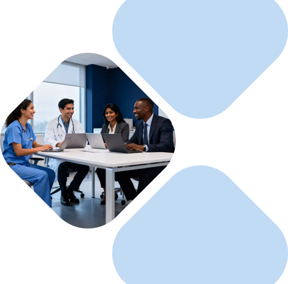 Medical professionals and a businessperson smiling and working on laptops in a meeting room.