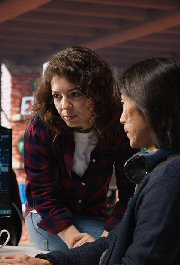 Green robotic vacuum cleaner operating on wooden floor in a bright living room with a sofa and glass coffee table.