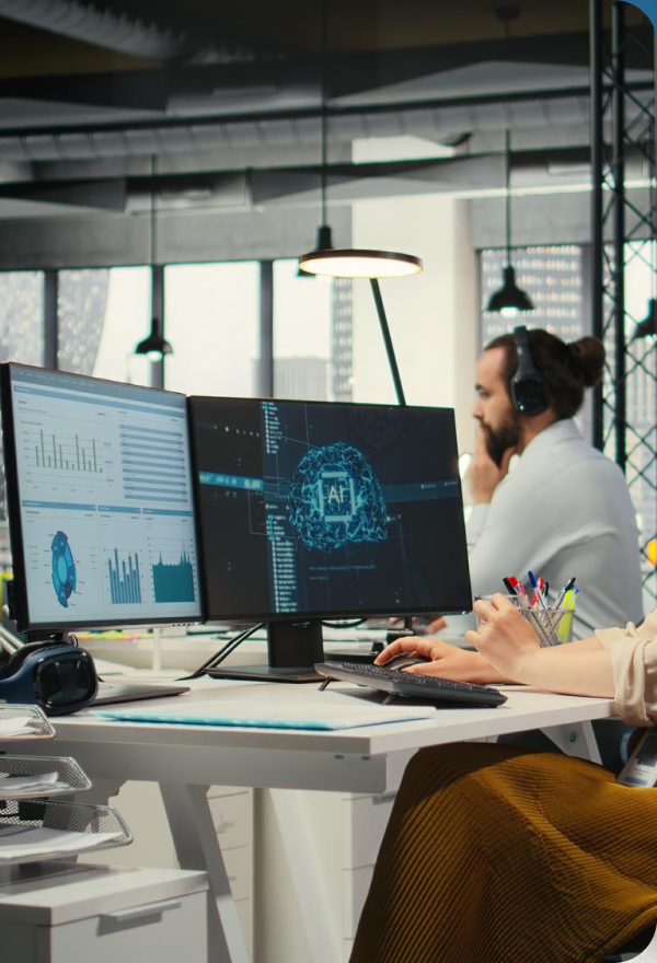 Three workers in orange uniforms cleaning a tree-lined street with leaves on the ground during autumn.