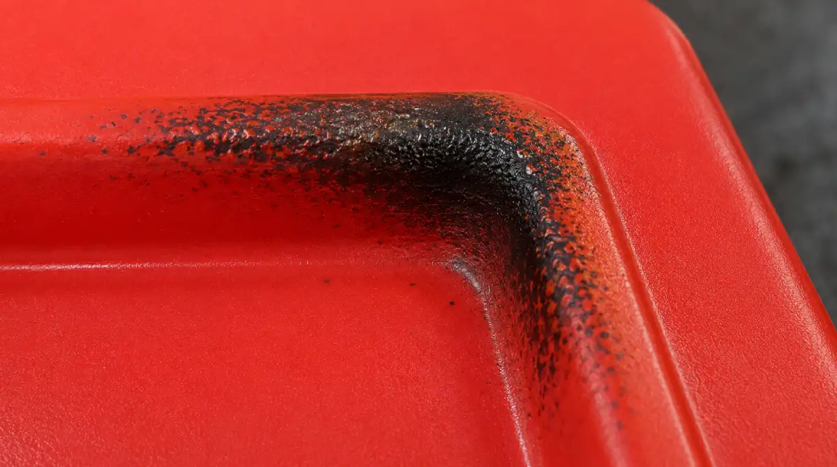 Close-up of bubbling and degraded HIPS panel with burn marks caused by overheating in vacuum forming oven