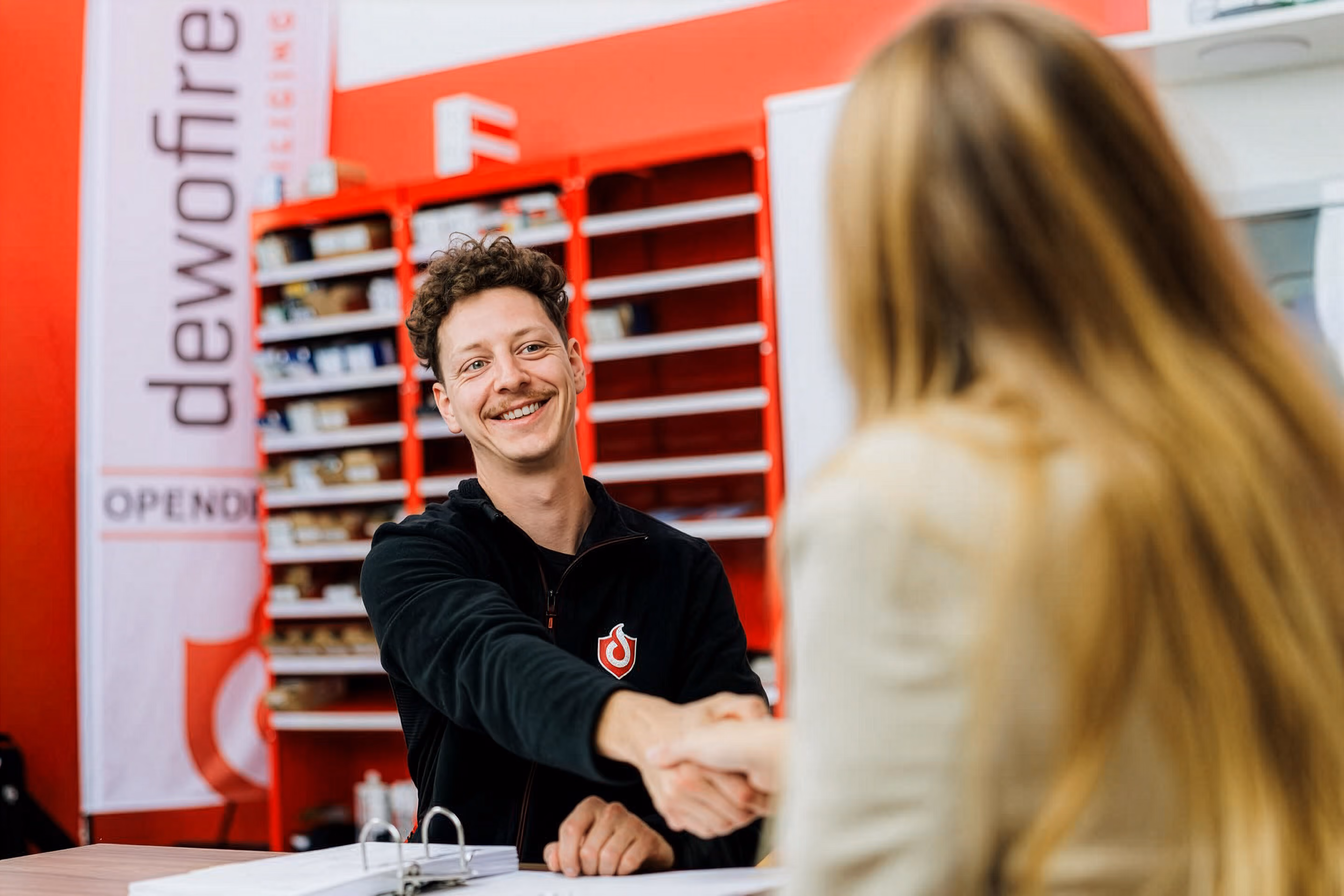 Man glimlacht, schudt een hand met een vrouw en zorgt voor persoonlijke begeleiding.