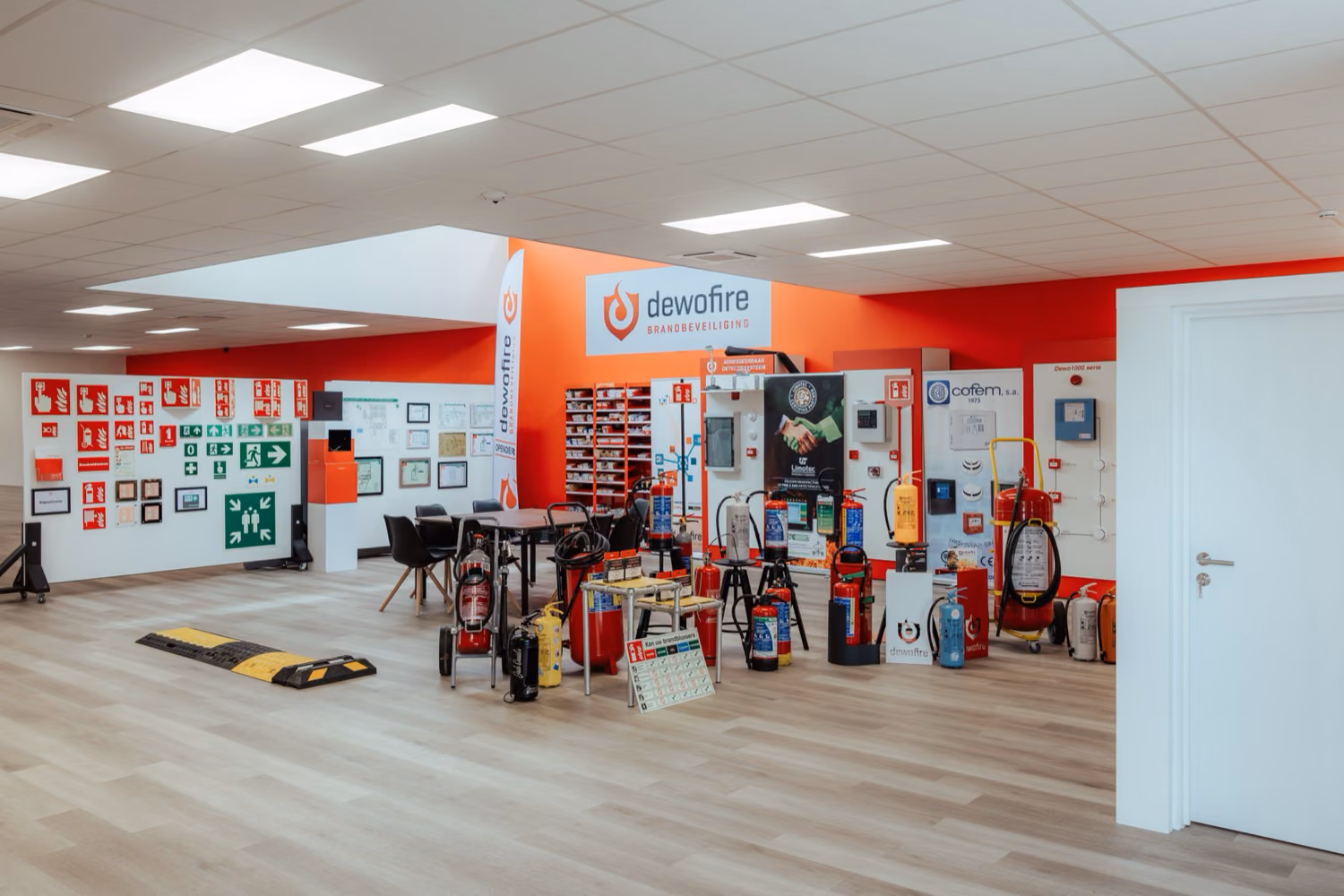 Binnenruimte met brandblussers, nooduitgangborden. Showroom van Dewofire
