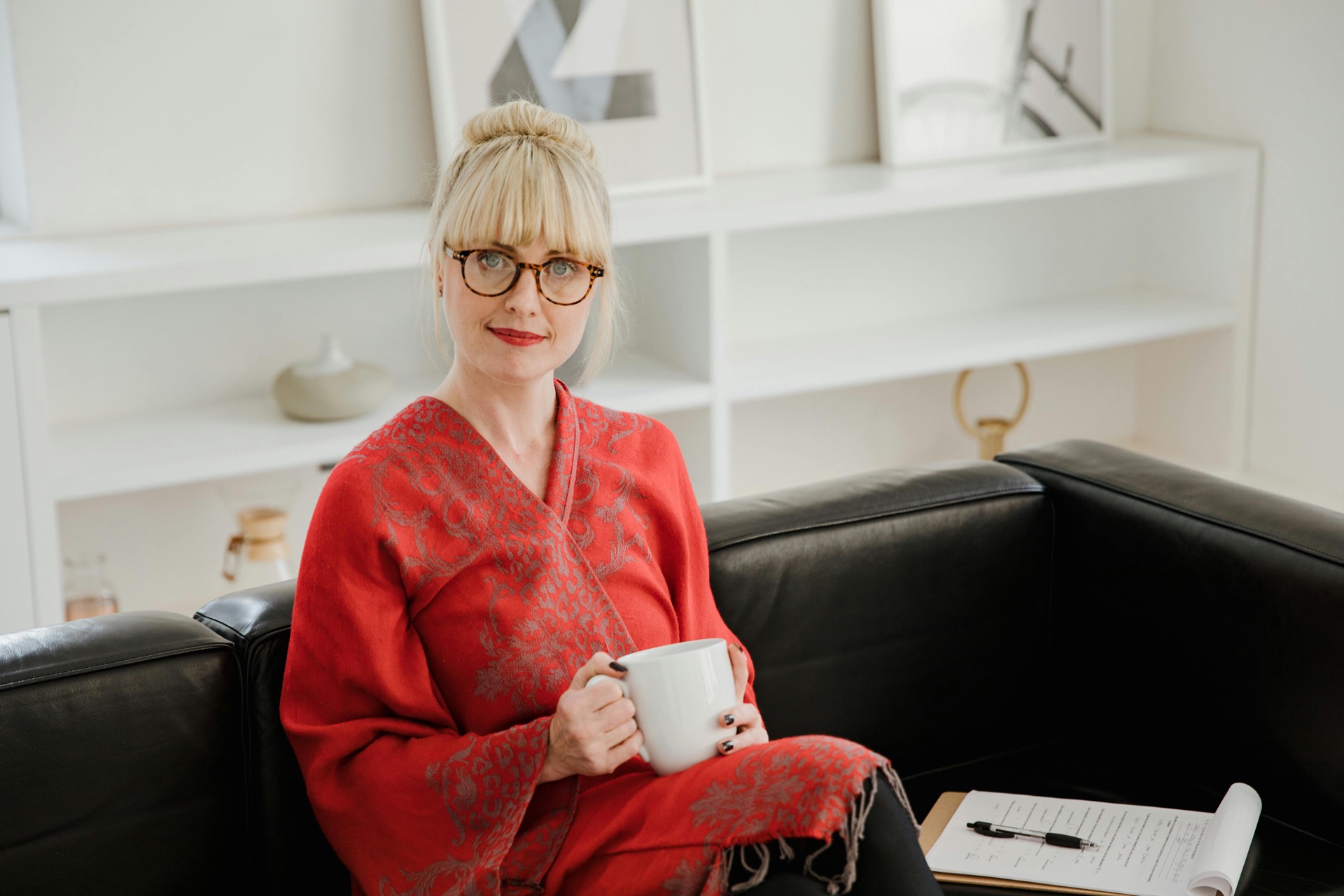Person sitting on tennis court wearing striped socks and white sneakers surrounded by tennis balls and a wooden tennis racket.