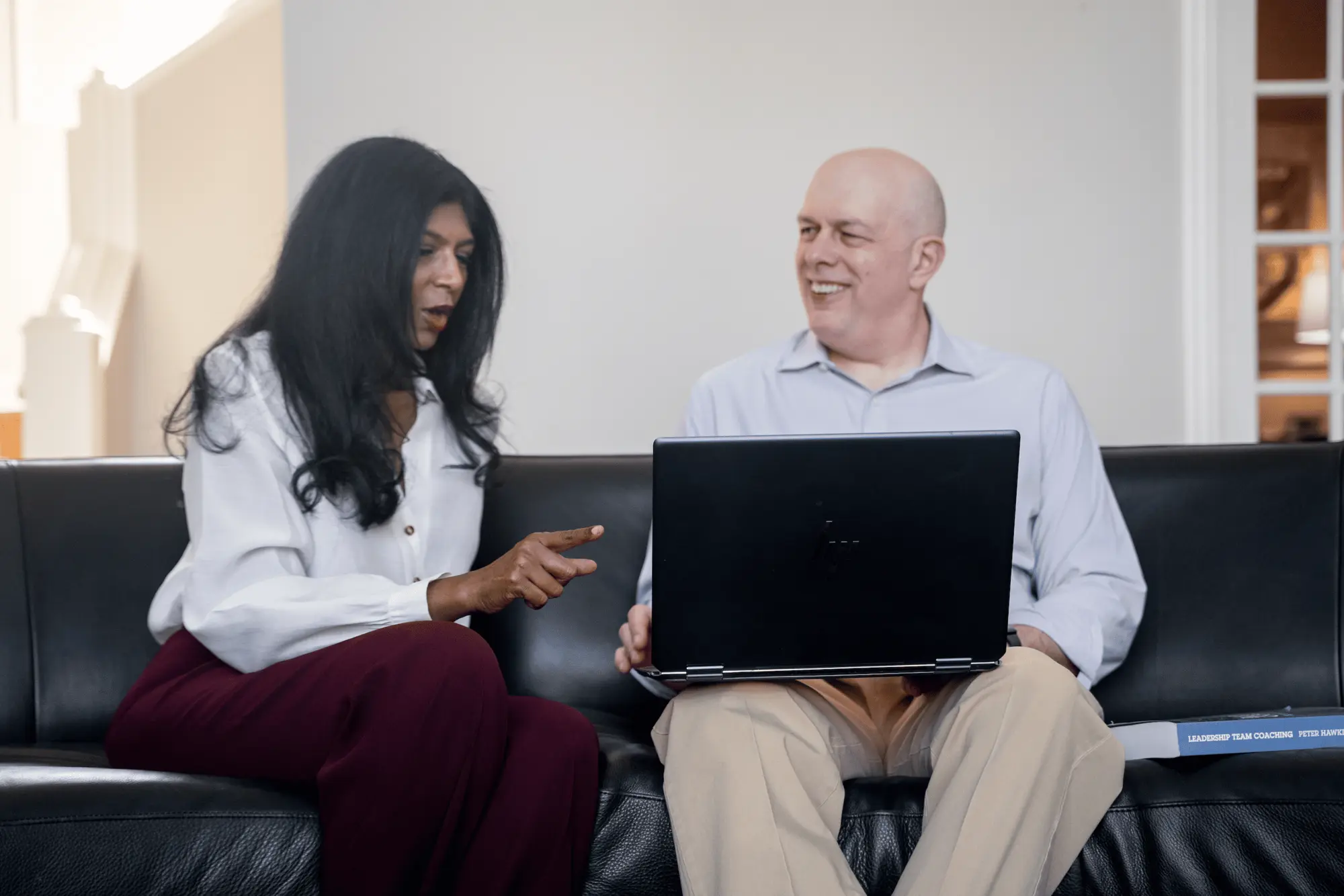 Sandhya and Matthew Johnson collaborating over a laptop during an Ingenium Global working session.