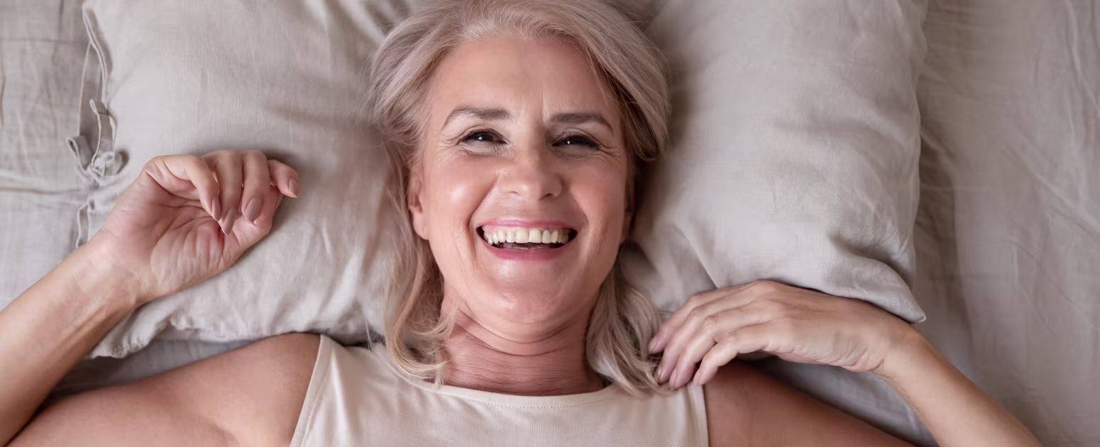 Smiling women post menopause who sleeps better with hypnosis.