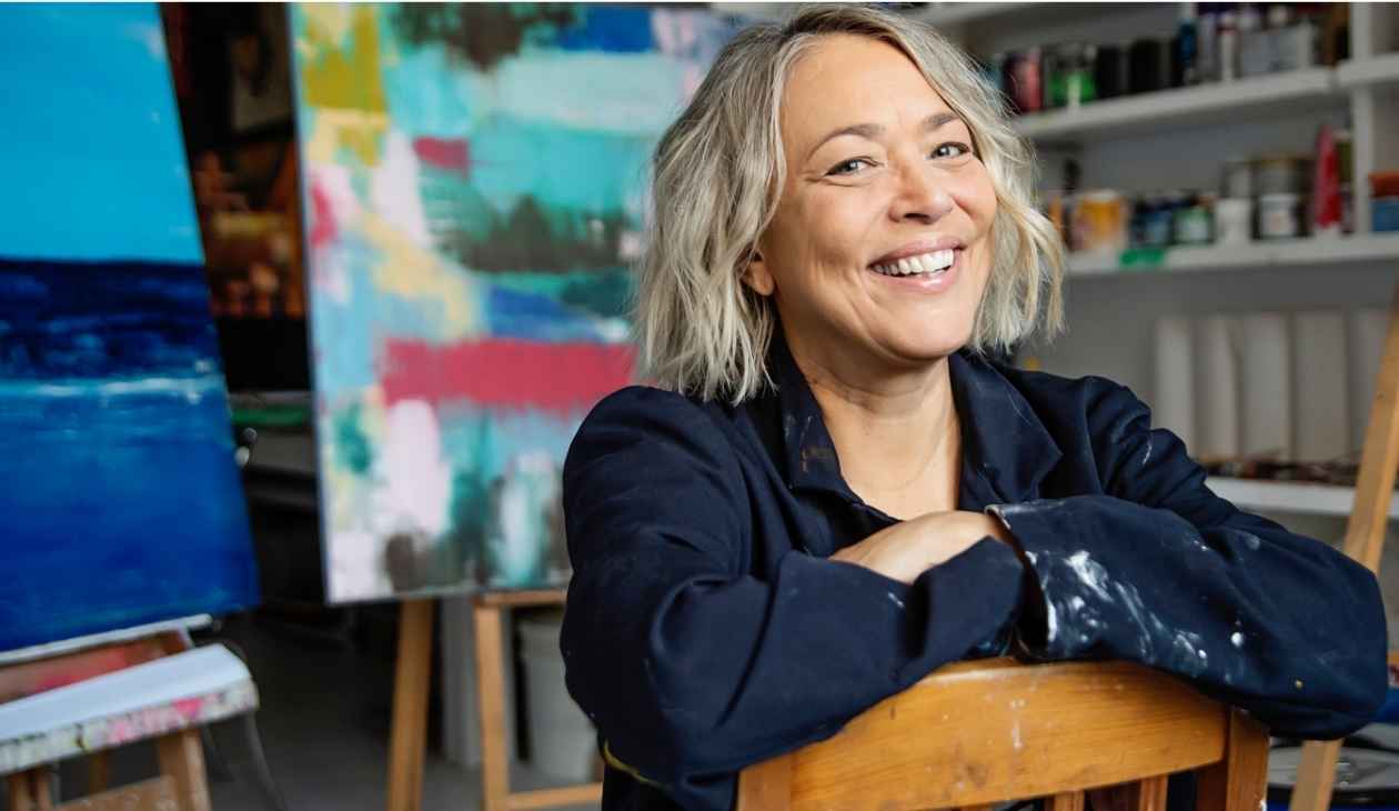 Anxiety-free postmenopausal woman smiling in her painting studio