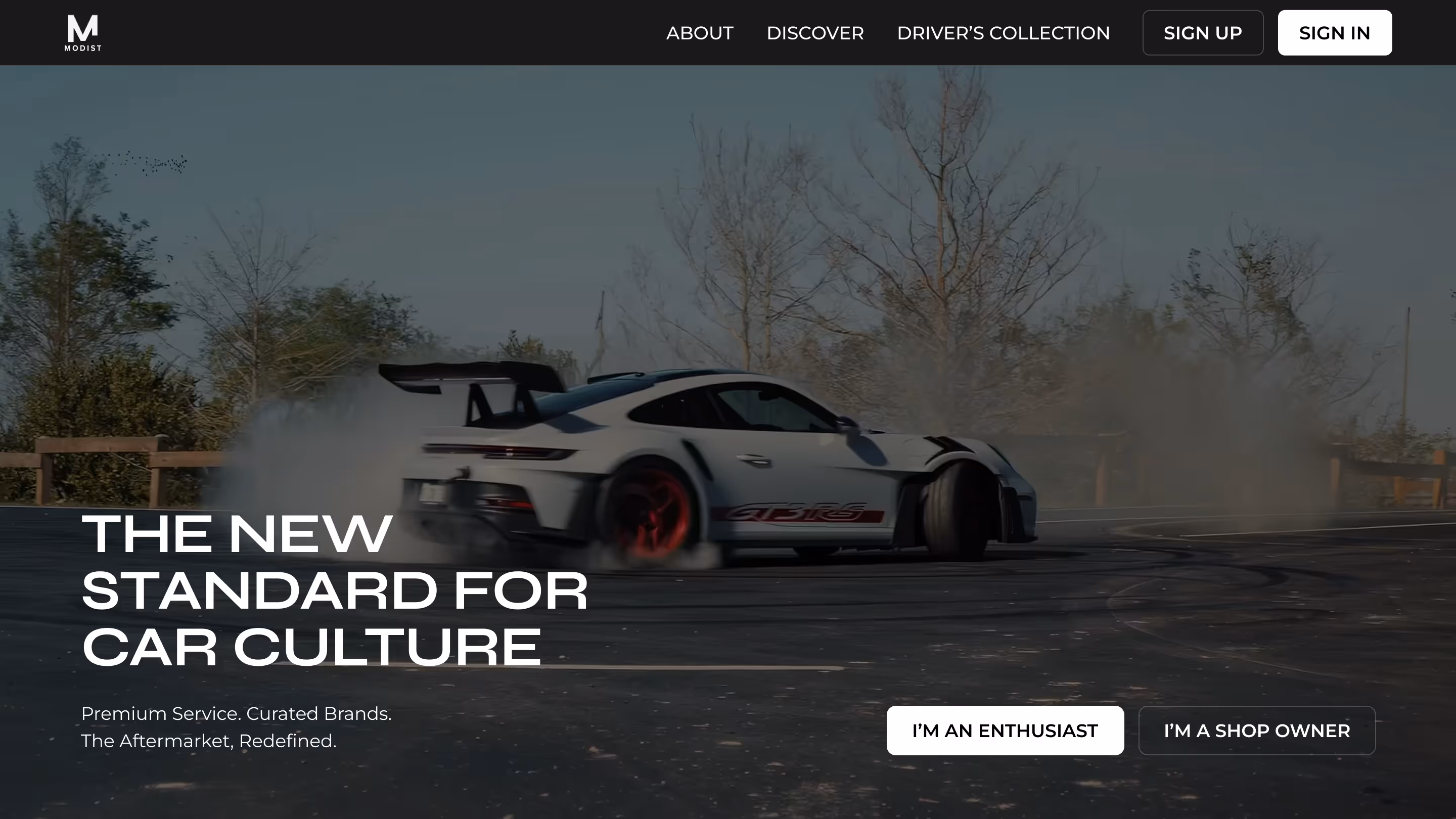 Hero section of Modist website featuring a Porsche doing a burnout
