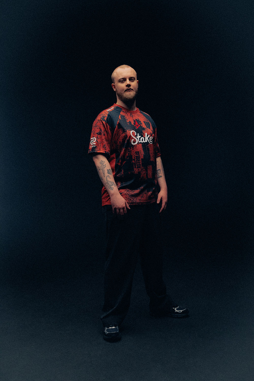 phzy standing in an Astralis jersey with tattoos visible on his forearms.