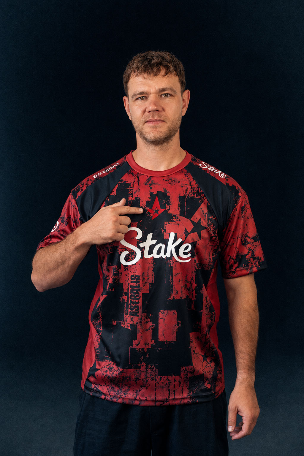 NEO pointing to the Astralis logo on his red and black team jersey.