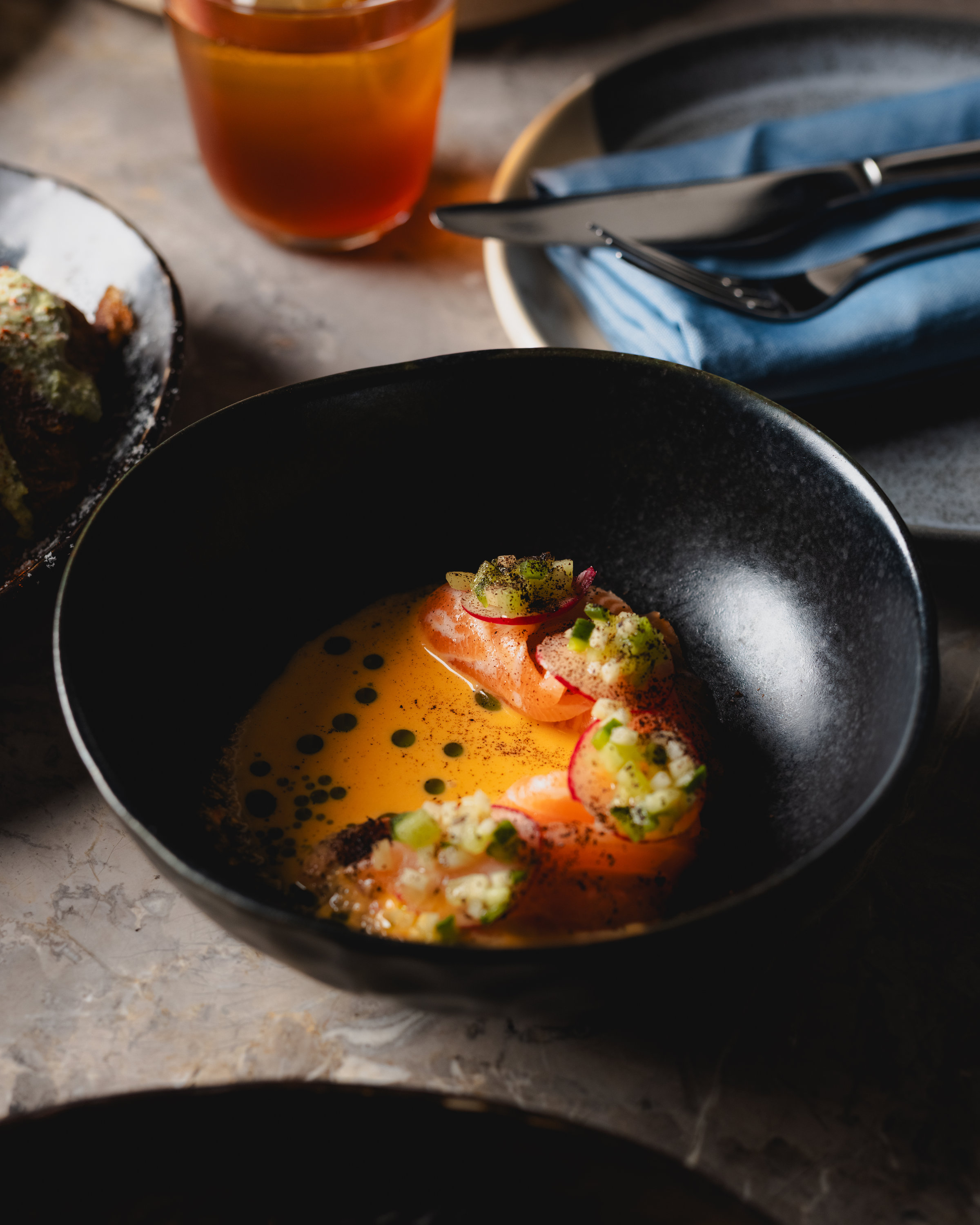 Salmon crudo on a set table at Maven