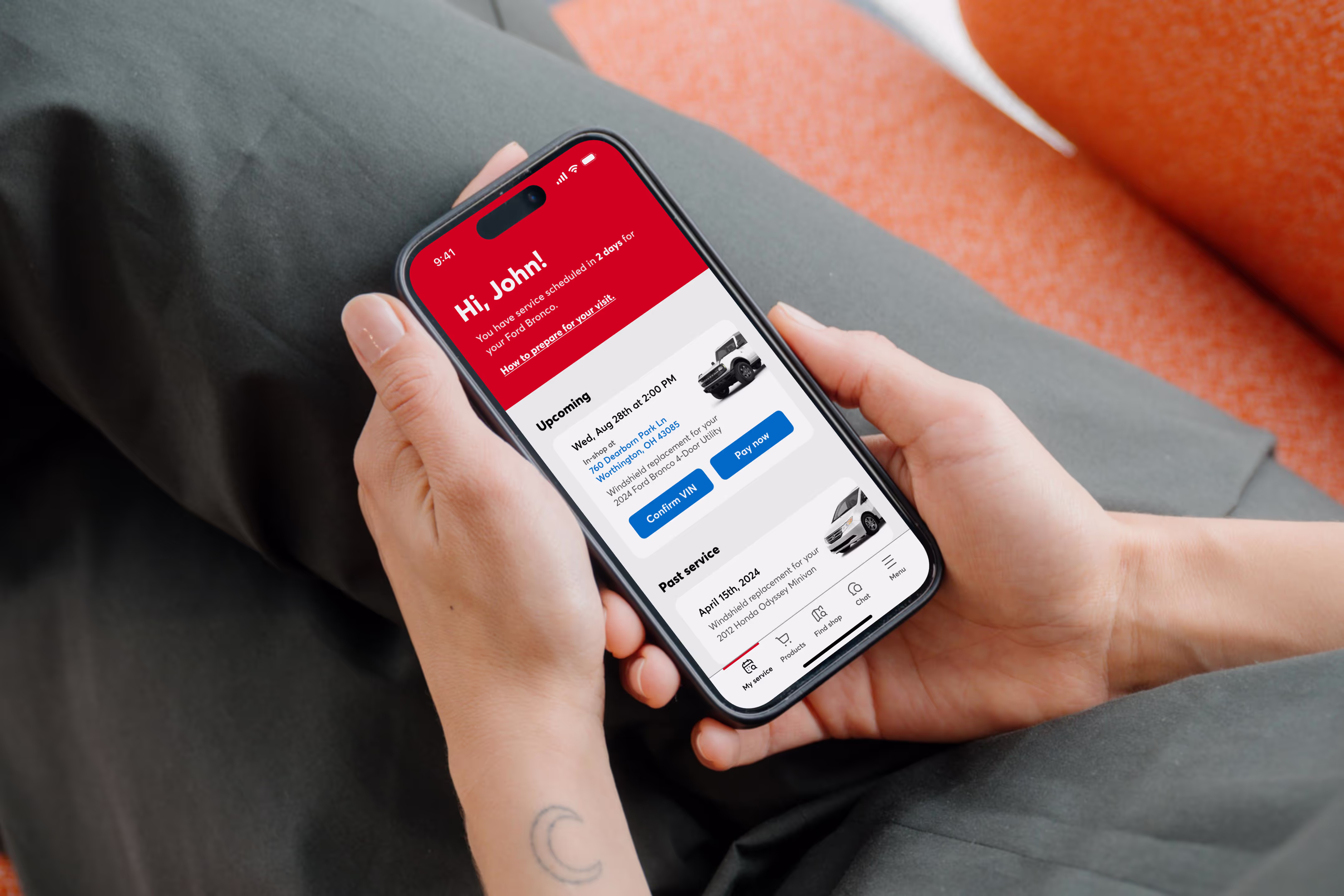 Person holding a smartphone showing a car service app with upcoming and past service details.