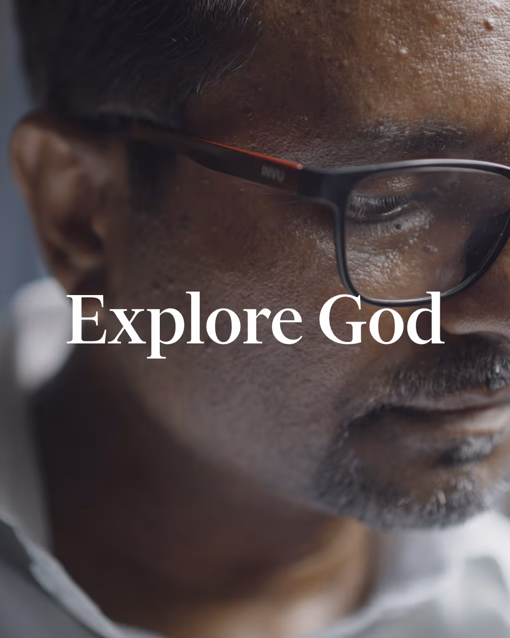 Close-up of a man wearing glasses with eyes closed and the text 'Explore God' overlayed.