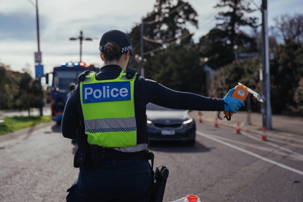 Police officer signalling a car to pull over for a breathalyser test