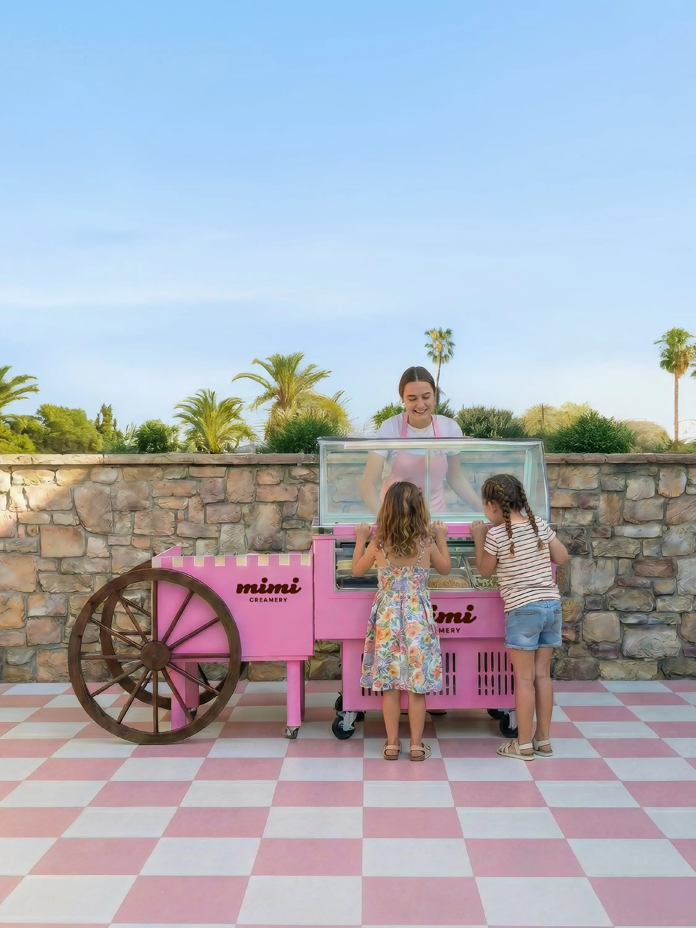 Two children at a pink Mimi Creamery ice cream cart served by a smiling woman outdoors.