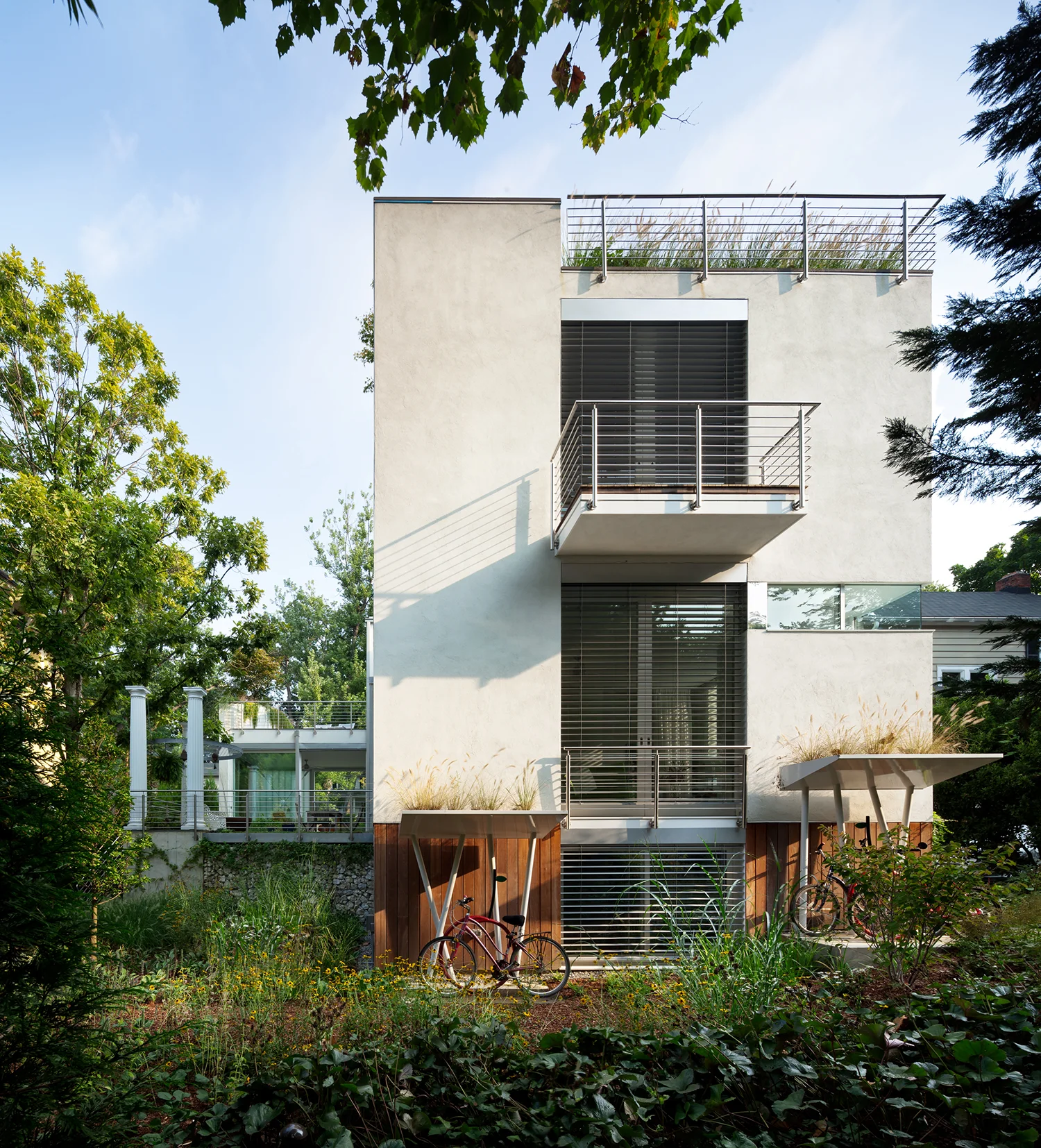 Rear facade with 3 visible floors, roof top garden with railing, 2nd floor balcony, and two bike storage sheds with plantings on top.