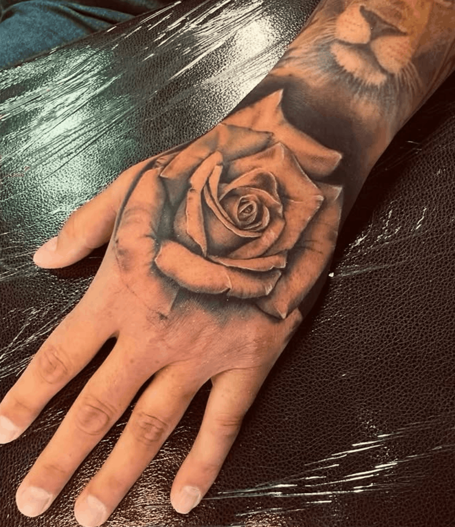 Tattoo of a rose on a hand by Noah Brewer