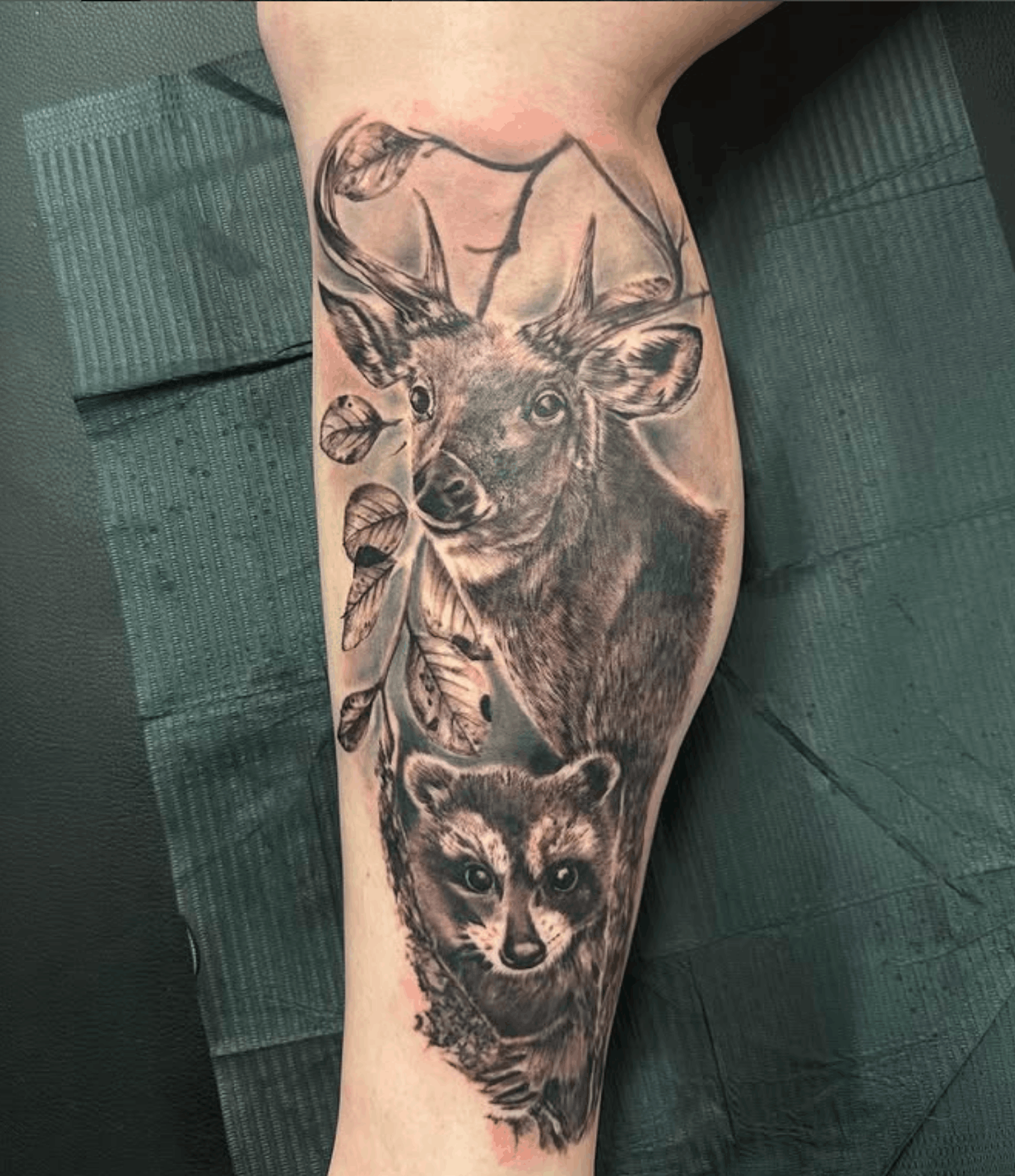 Tattoo of a deer and raccoon by Noah Brewer