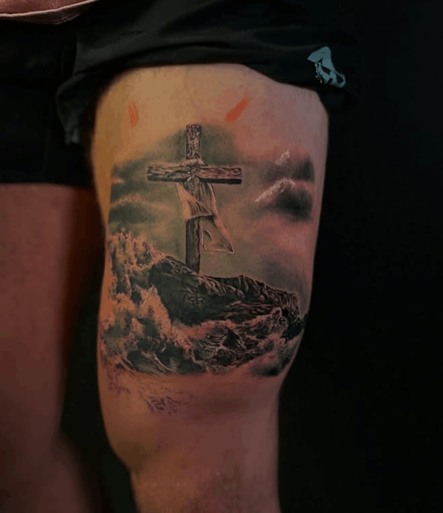 Tattoo of a Crucifixion Cross with the ocean in front of it by Noah Brewer