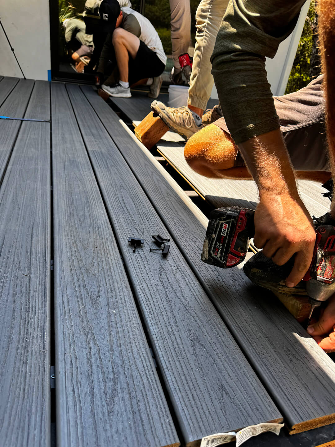 Close-up of Rivolty builders installing composite decking boards