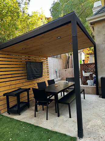 Modern solid patio cover with a wood ceiling, privacy screen, and outdoor dining area in the San Francisco Bay Area.
