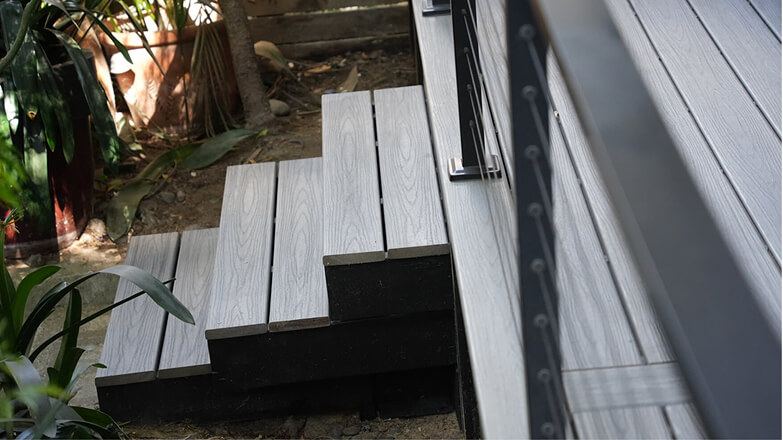 Modern composite backyard deck with black aluminum railings