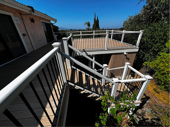 Modern composite backyard deck with black aluminum railings