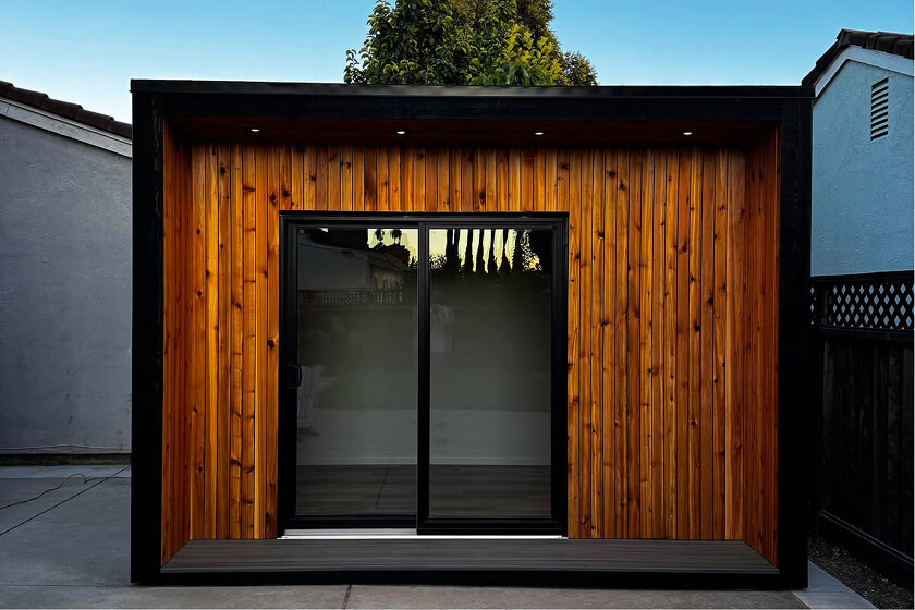 Redding shed with modern dark wood siding and black double doors