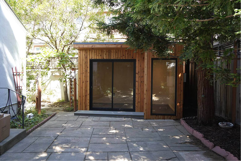 Completed Stockton backyard office shed with premium wood exterior and large sliding glass door