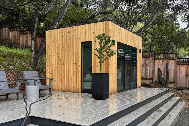 Modern Cube backyard shed with a flat roof, cedar wood siding, black aluminum windows, and sliding glass doors by Rivolty