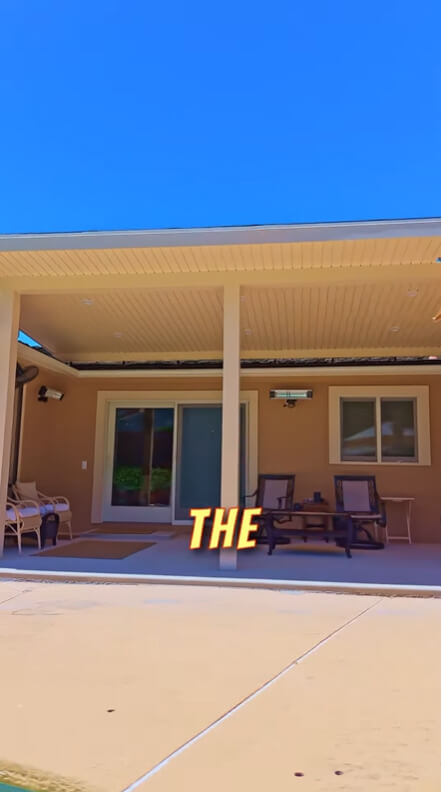 Modern backyard patio area featuring a tongue-and-groove ceiling, mounted patio heaters, and comfortable seating, designed for outdoor relaxation.