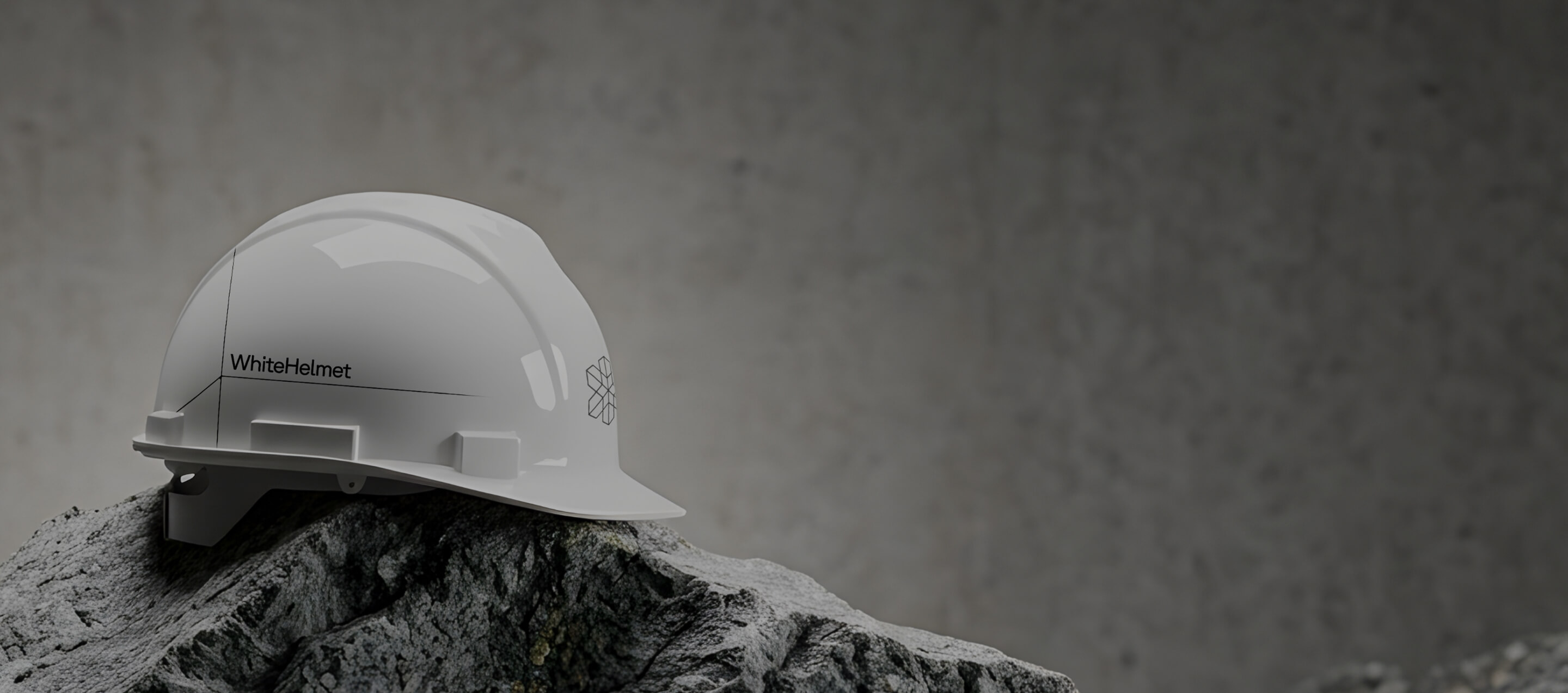Helmet sitting on a rock with WhiteHelmet logo