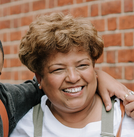 Smiling young man with short light brown hair wearing a light blue button-up shirt.
