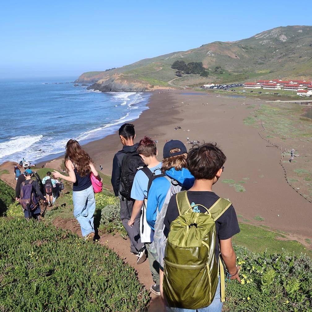 Young people walking on path down to the beach in Golden Gate