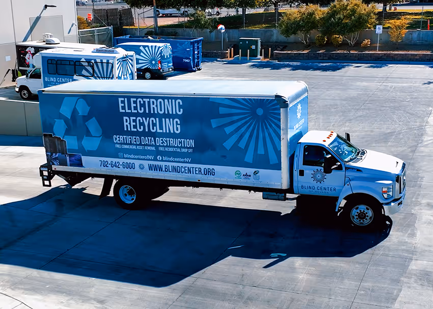 Blue and white Blind Center of Nevada truck parked on pavement with text promoting electronic recycling and certified data destruction services.