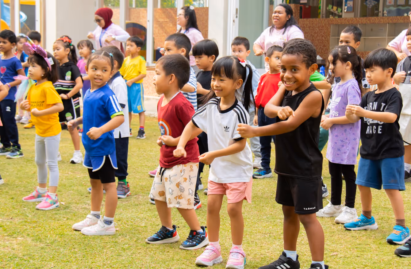 Students dancing together on grass. 