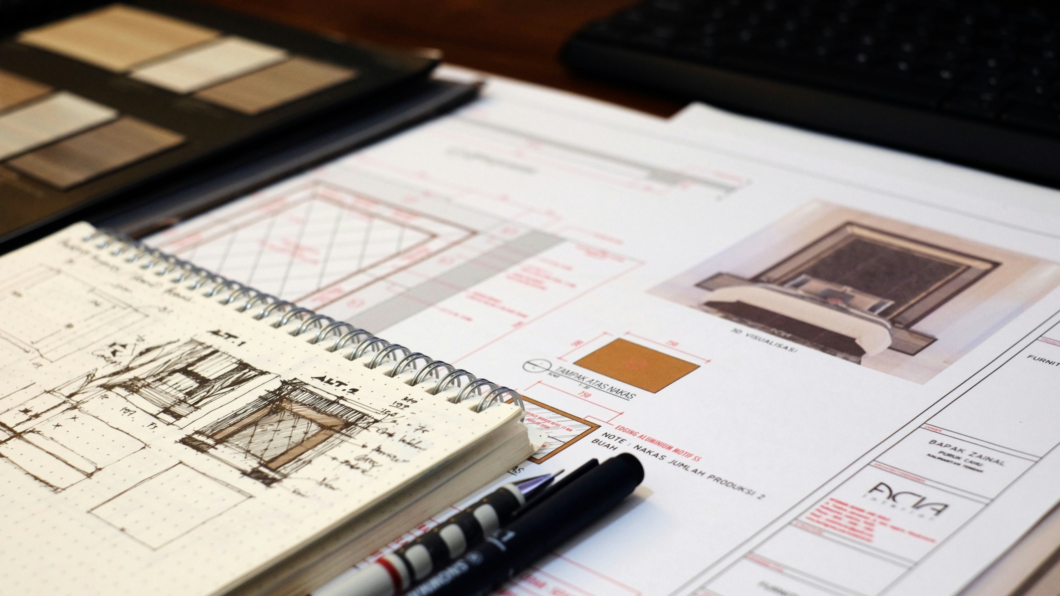 Architectural sketches and technical drawings of a bedroom design with pens on a desk.