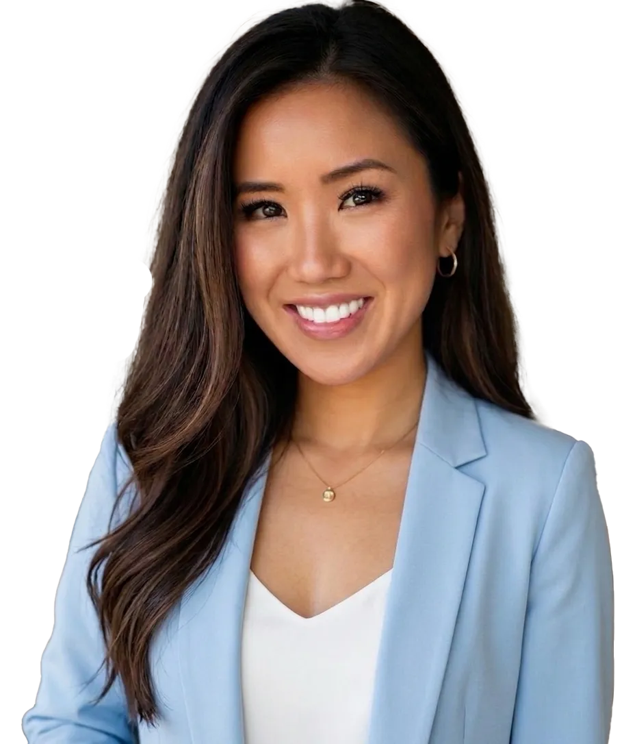 Smiling woman with long dark hair wearing a strapless black top against a black background.