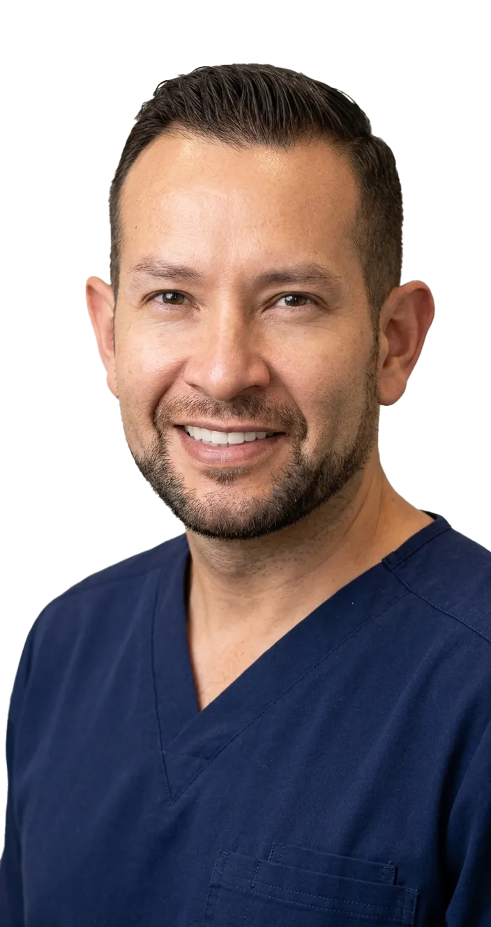 Smiling man wearing a beige checked suit jacket, white shirt, and light pink tie.