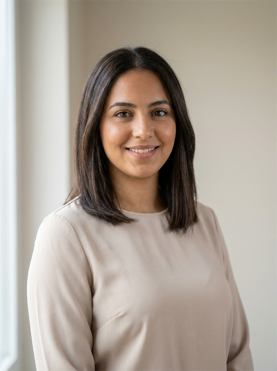 Portrait de Sarah AHKAF, coordinatrice administrative au sein de CSE Compétences, vêtue d'un chemisier beige clair devant un mur neutre.