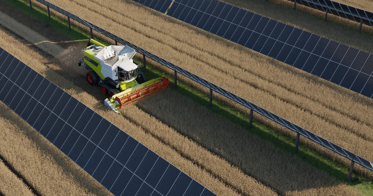 Un tracteur sur une parcelle agricole entouré d'ombrières agrivoltaïques dédiées aux cultures