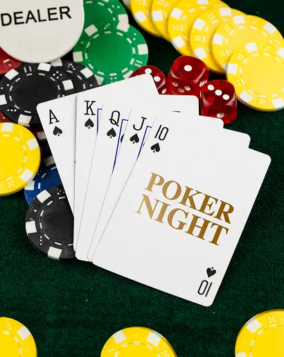 Royal flush poker hand with Ace, King, Queen, Jack, and 10 of spades, poker chips, red dice, and dealer button on green felt.