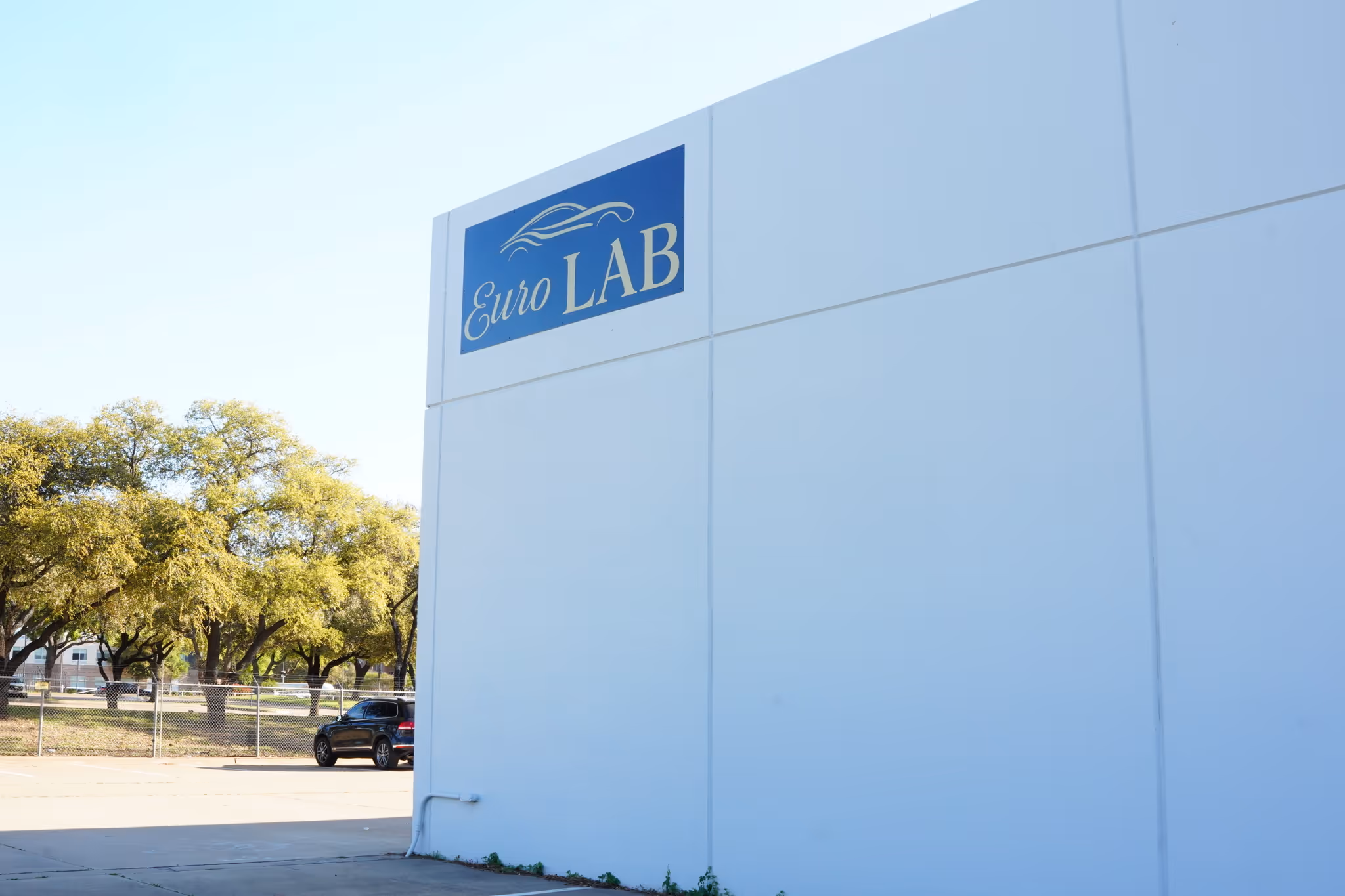 White building exterior with a blue Euro LAB sign featuring a car outline.