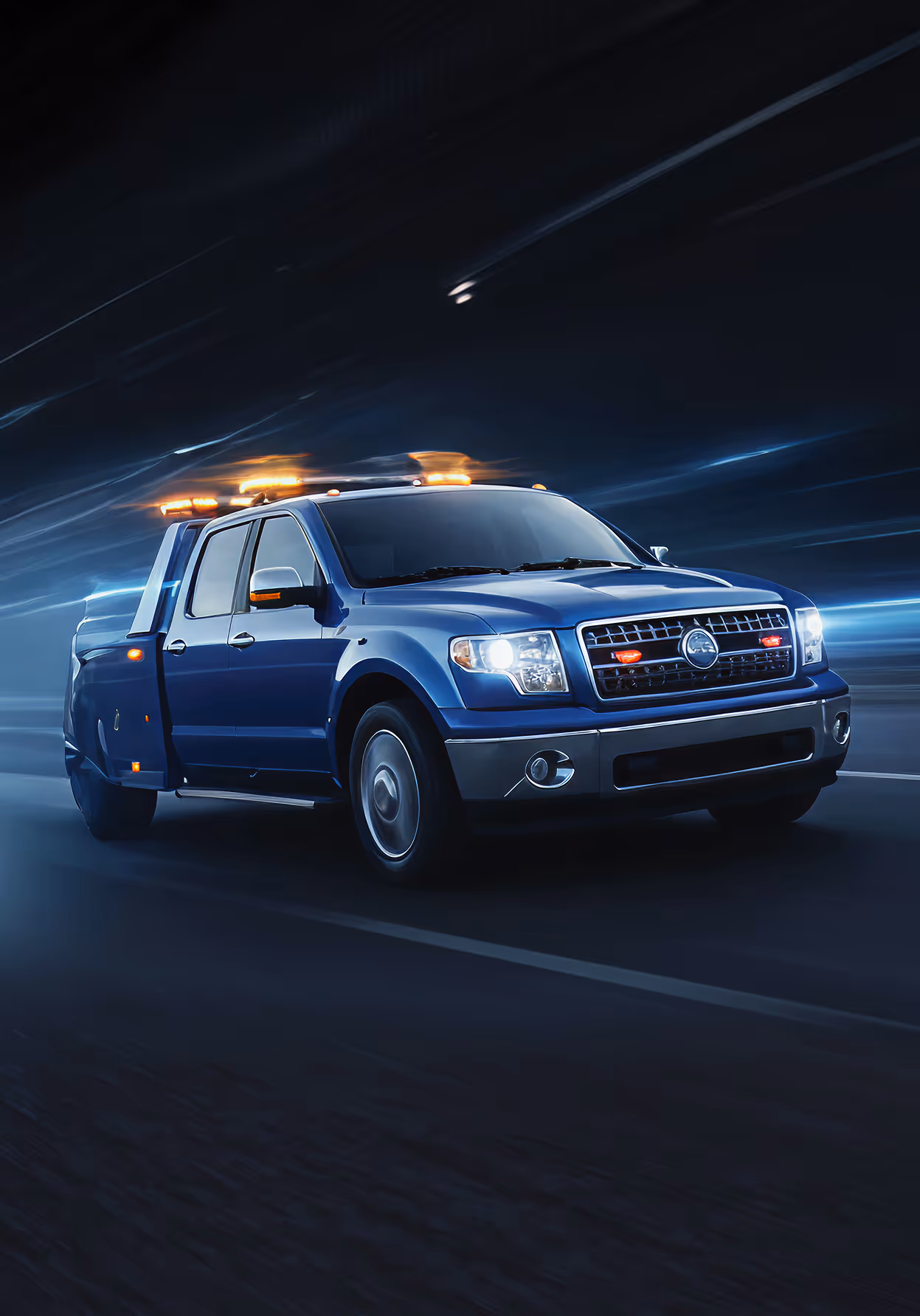 Blue tow truck with flashing lights driving fast at night on a dark road.