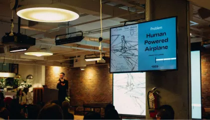 a man standing in front of a projection screen