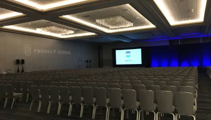 a room with rows of chairs and a projector screen