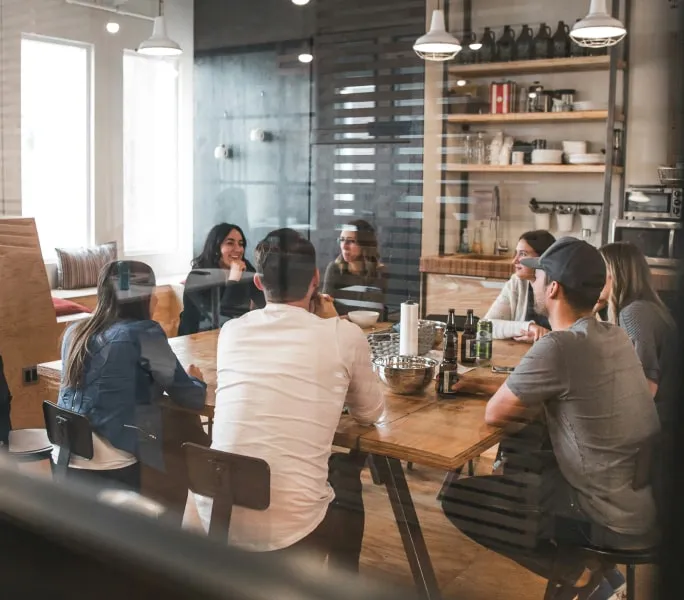 a group of people sitting around a wooden table