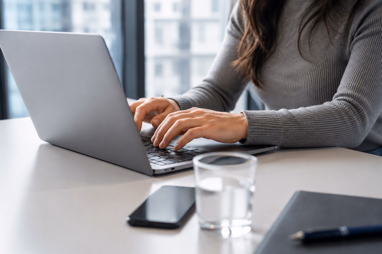 Frau arbeitet konzentriert am Laptop im Büro