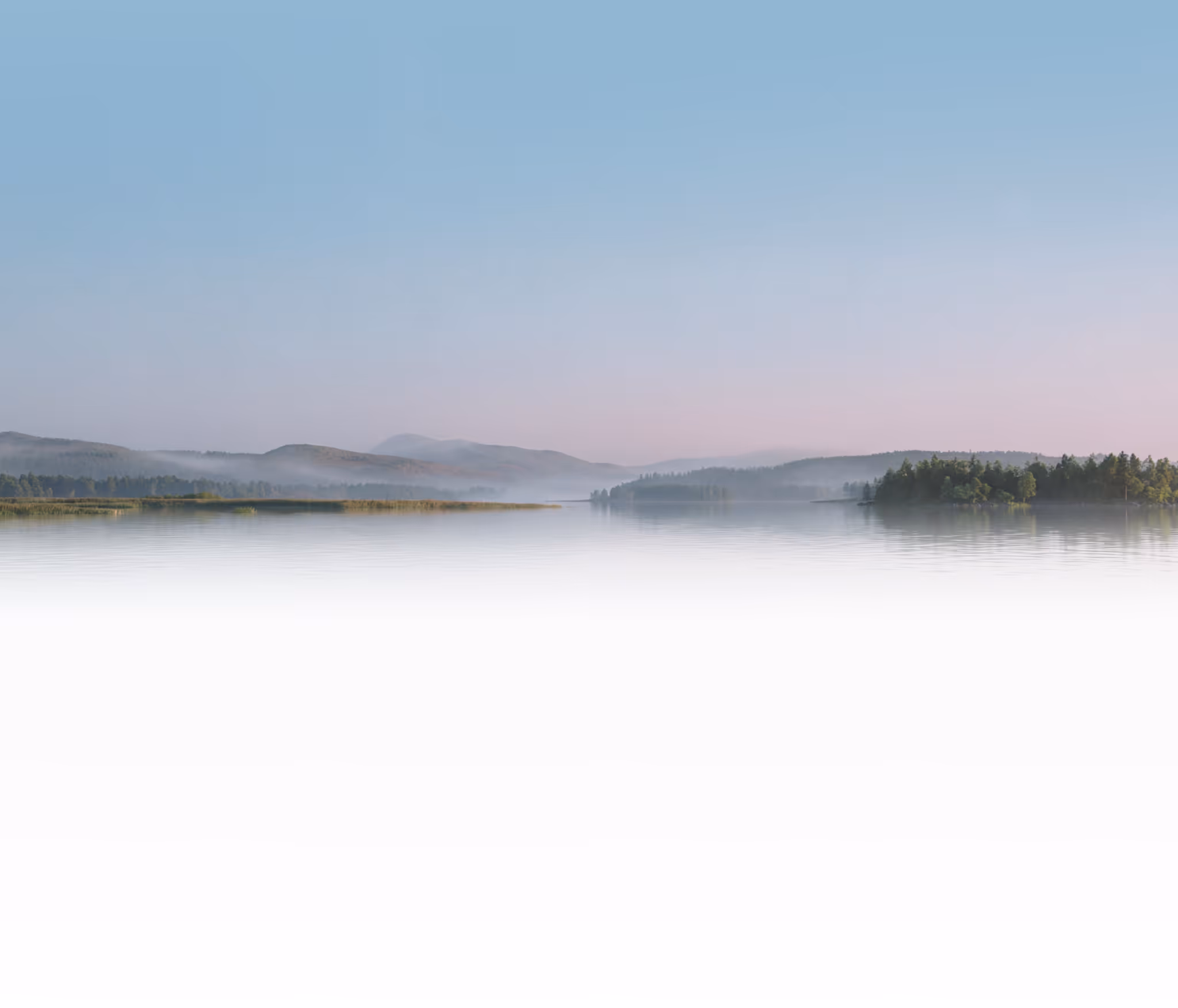 A beautiful Finnish sunset over a lake with mountains in the background.