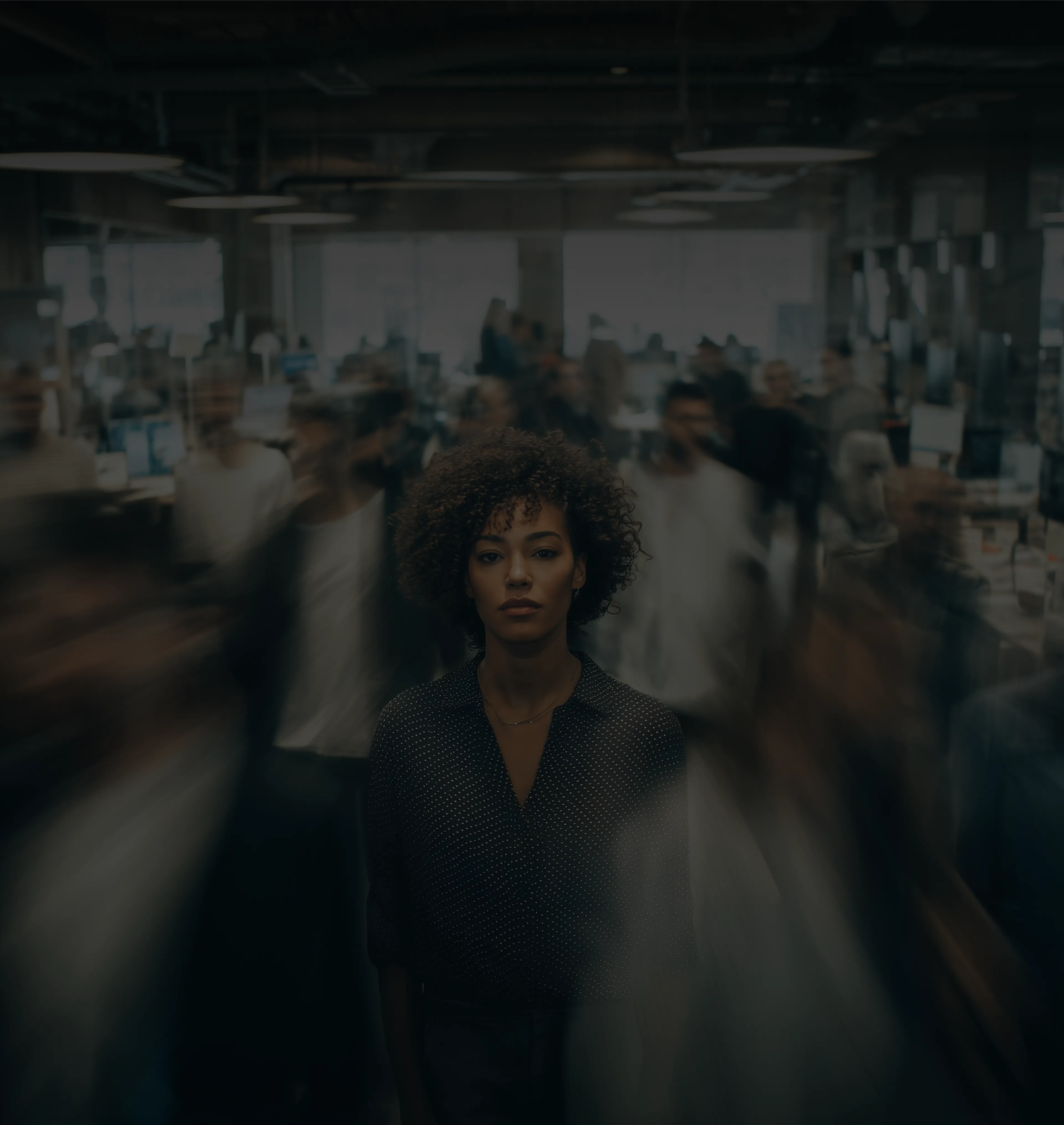 a person standing still looking into the camera in the middle of people walking by in a rush