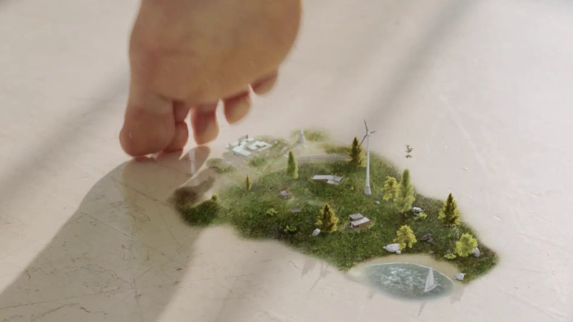 A foot leaves a footprint of a sustainable island ecosystem with wind turbines, trees, farm buildings, and a pond – hero image from the EPEA Cradle to Cradle consulting brand case by VANDUER